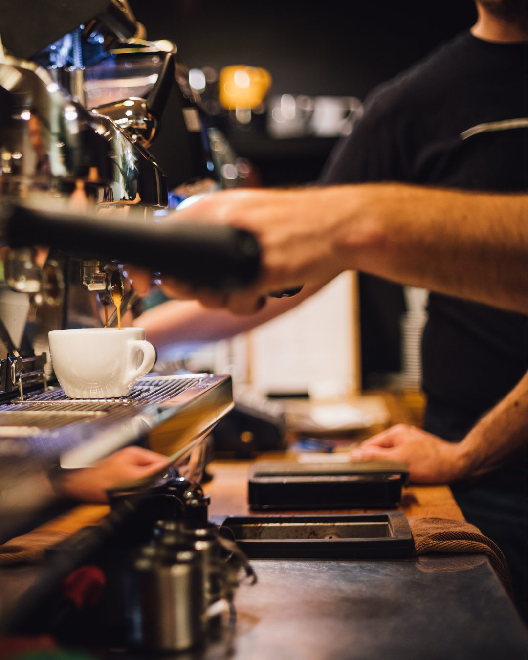 Close up of a person making a coffee in a cafe