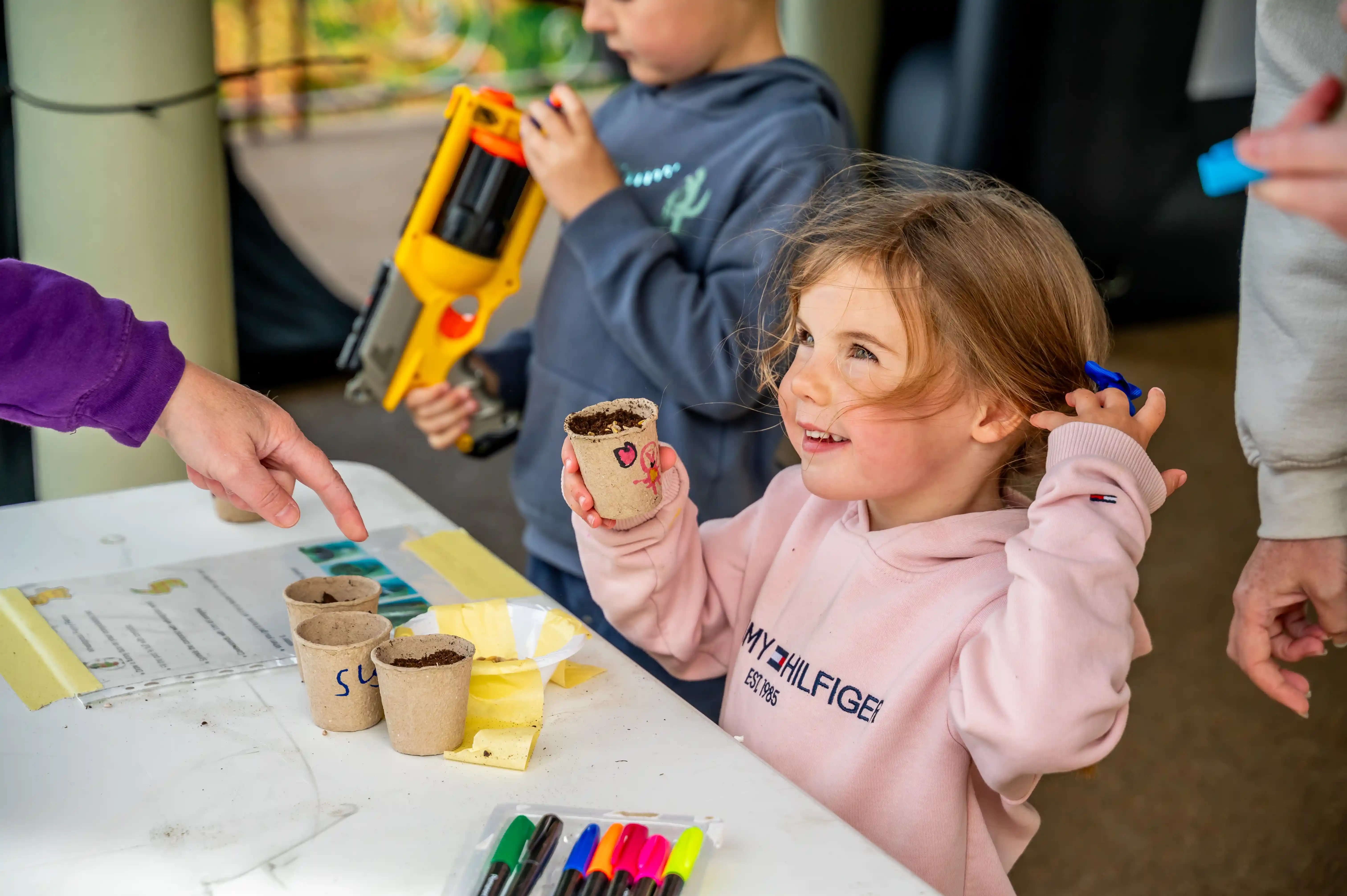 Young girl holding up seed pot at Lanarkshire Climate Action Festival 2024 - Photography by Lucy Knott